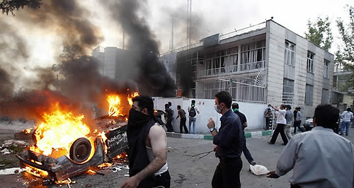재선거를 요구하는 이란 시위대에 의해 민병대의 차량이 불타고 있다.