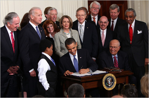 환하게 웃으며 건강보험 개혁 법안에 서명하고 있는 버락 오바마 대통령.