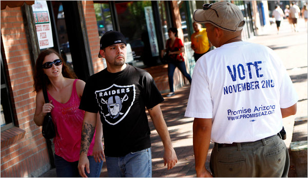 한 자원 봉사자가 길거리에서 지나가는 커플에게 투표를 할 것을 권하고 있다