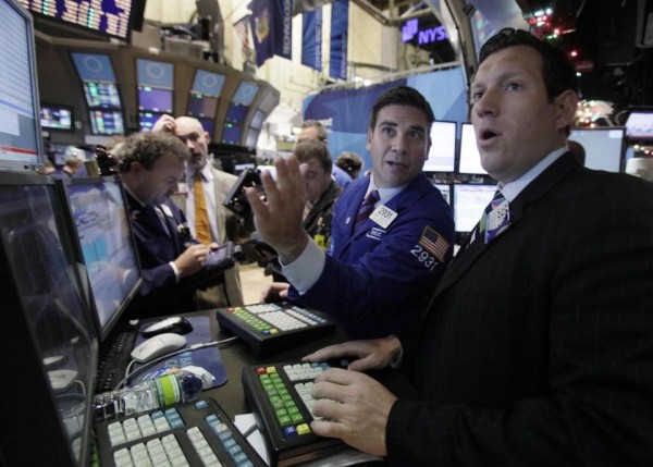 뉴욕 증권 시장의 투자자들이 증시 현황판을 보며 놀라고 있다