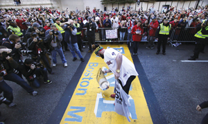 보일스턴 스트릿의 피니쉬 라인에 우승 트로피를 놓고 있는 조니 고메스