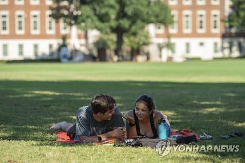 미 앨라배마대학 터스컬루사 캠퍼스에서 남녀 학생이 잔디밭에 엎드려 얘기하고 있다