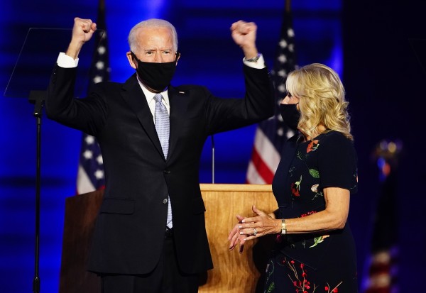 조 바이든 미국 대통령 당선인이 7일(현지시간) 델라웨어주 윌밍턴에서 승리를 선언하는 연설을 마친 뒤 부인 질 바이든 여사(오른쪽)가 지켜보는 가운데 두 손을 들어올리고 있다