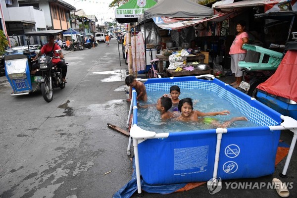 지난 3일(현지시간) 필리핀 마닐라의 한 거리에서 어린이들이 폭염을 피하기 위해 임시변통으로 만든 작은 풀장에서 물놀이하고 있다. 최근 필리핀 등 동남아에서는 체감온도가 섭씨 50도를 넘나드는 폭염이 나타나면서 피해가 잇따르고 있다.