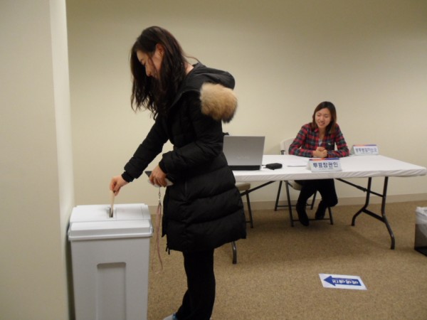 18대 대통령 재외선거가 시작된 투표 첫날 투표소 문이 열리자 가장 먼저 투표한 유학생 김정화 씨가 투표함에 투표지를 넣고 있다.