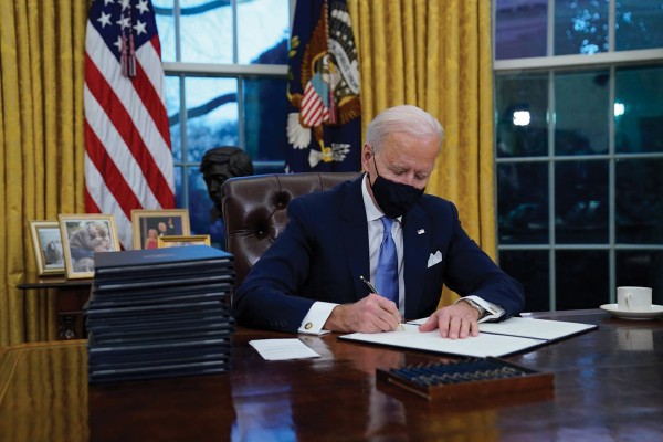조셉 바이든 대통령이 20일 취임 첫날 백악관에서 트럼프 행정부의 정책을 바로잡는 행정명령에 서명하고 있다