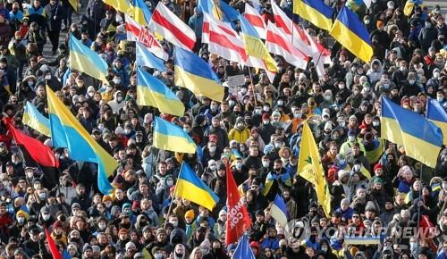 러시아의 우크라이나 침공 우려가 커지는 가운데 12일(현지시간) 우크라이나 시민 수천명이 수도 키예프 거리로 나와 러시아의 위협에 맞서 단결하겠다는 의지를 내보이며 국기를 든 채 행진에 참여하고 있다.