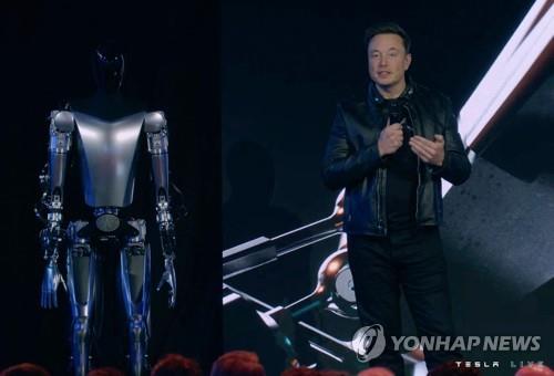 일론 머스크 테슬라 최고경영자(CEO)가 30일(현지시간) 미국 캘리포니아주 팰로앨토에서 열린 '테슬라 AI 데이' 행사 무대에 휴머노이드 로봇 '옵티머스'와 함께 서 있다.