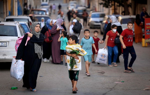 팔레스타인 여성들과 어린이들이 13일(현지시간) 가자지구 중심 도시 가자시티에서 짐을 챙겨 더 안전한 지역으로 피신하고 있다. 이스라엘은 팔레스타인 무장 정파 하마스와의 무력 충돌 이레째인 이날 가자시티 주민 전원에게 대피령을 내렸다.